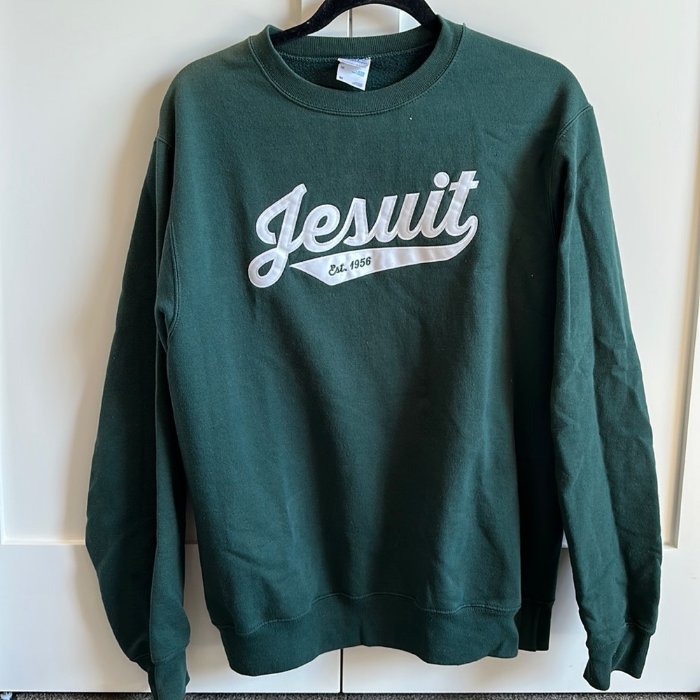 Forest green crewneck with white text: “Jesuit”